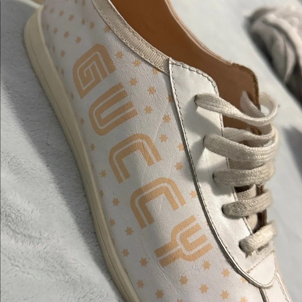 GUCCI Falacer low-top sneaker in white leatherprint in gold and star detailing.